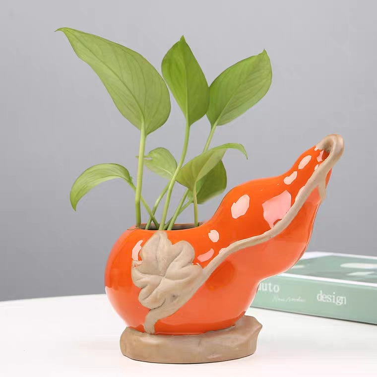 Whimsical orange ceramic vase with plant cutting — hydroponic home decor